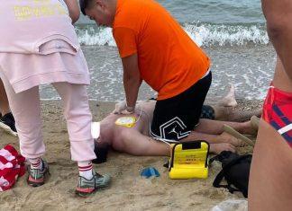 (FOTO) SRBIN LEŽI NA PESKU BEZ SVESTI, POKUŠAVAJU DA MU SPASU ŽIVOT Dramatične slike akcije na plaži u Grčkoj: Prvi u pomoć pritekao vlasnik bara, pa se uključili i spasioci (foto)-srbin-lezi-na-pesku-bez-svesti,-pokusavaju-da-mu-spasu-zivot-dramaticne-slike-akcije-na-plazi-u-grckoj:-prvi-u-pomoc-pritekao-vlasnik-bara,-pa-se-ukljucili-i-spasioci